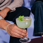 Bottle with Basil Breeze mocktail 99cl and mocktail glass filled with the Basil Breeze mocktail