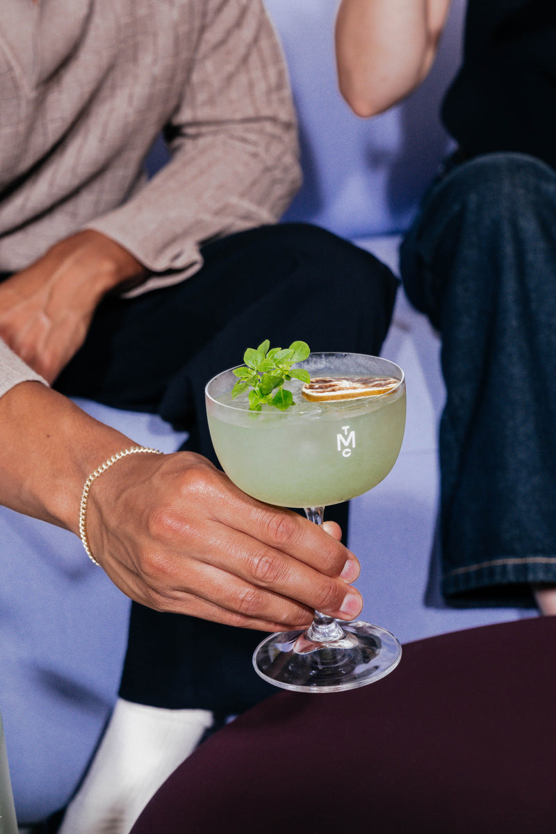 Bottle with Basil Breeze mocktail 99cl and mocktail glass filled with the Basil Breeze mocktail