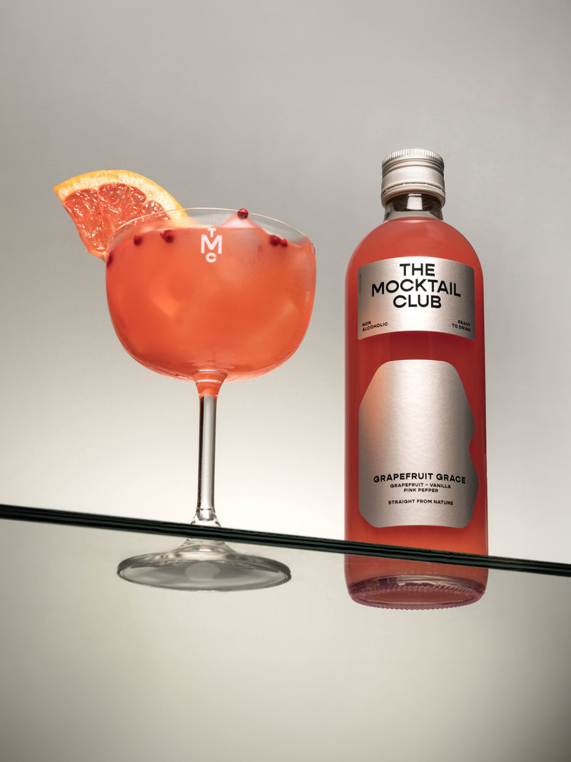 Small bottle of 49 cl Grapefruit Grace and The Mocktail Club glass filled with this mocktail