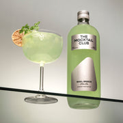 Bottle with Basil Breeze mocktail 99cl and mocktail glass filled with the Basil Breeze mocktail