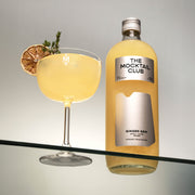Bottle with Ginger Gem mocktail 99cl and a glass filled with Ginger Gem mocktail