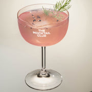 Mocktail glass filled with icecubes, Rhubarb Rush mocktail, finished with dill and timut pepper