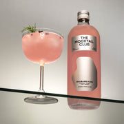 Bottle with Rhubarb Rush 99cl and glass filled with ice cubes, Rhubarb Rush mocktail, finished with dill and timut pepper