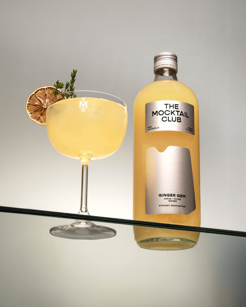 Bottle with Ginger Gem mocktail 99cl and a glass filled with Ginger Gem mocktail