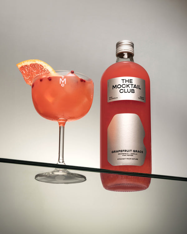 Bottle with Grapefruit Grace mocktail 99cl and mocktail glass filled with the Grapefruit Grace mocktail 